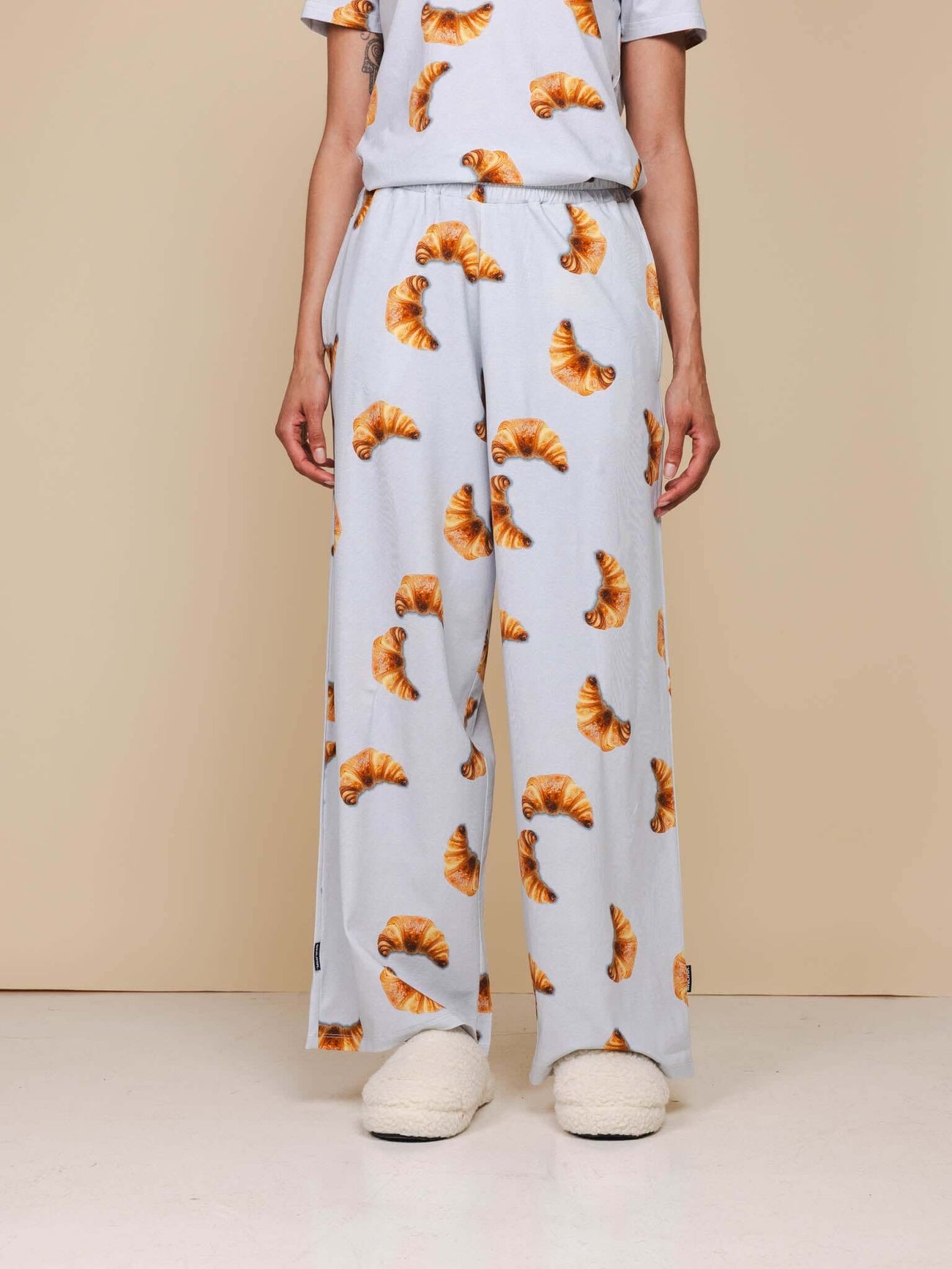 SNURK Croissants Wijde Broek Dames met croissantjes patroon, wijde pijpen en comfortabel design.