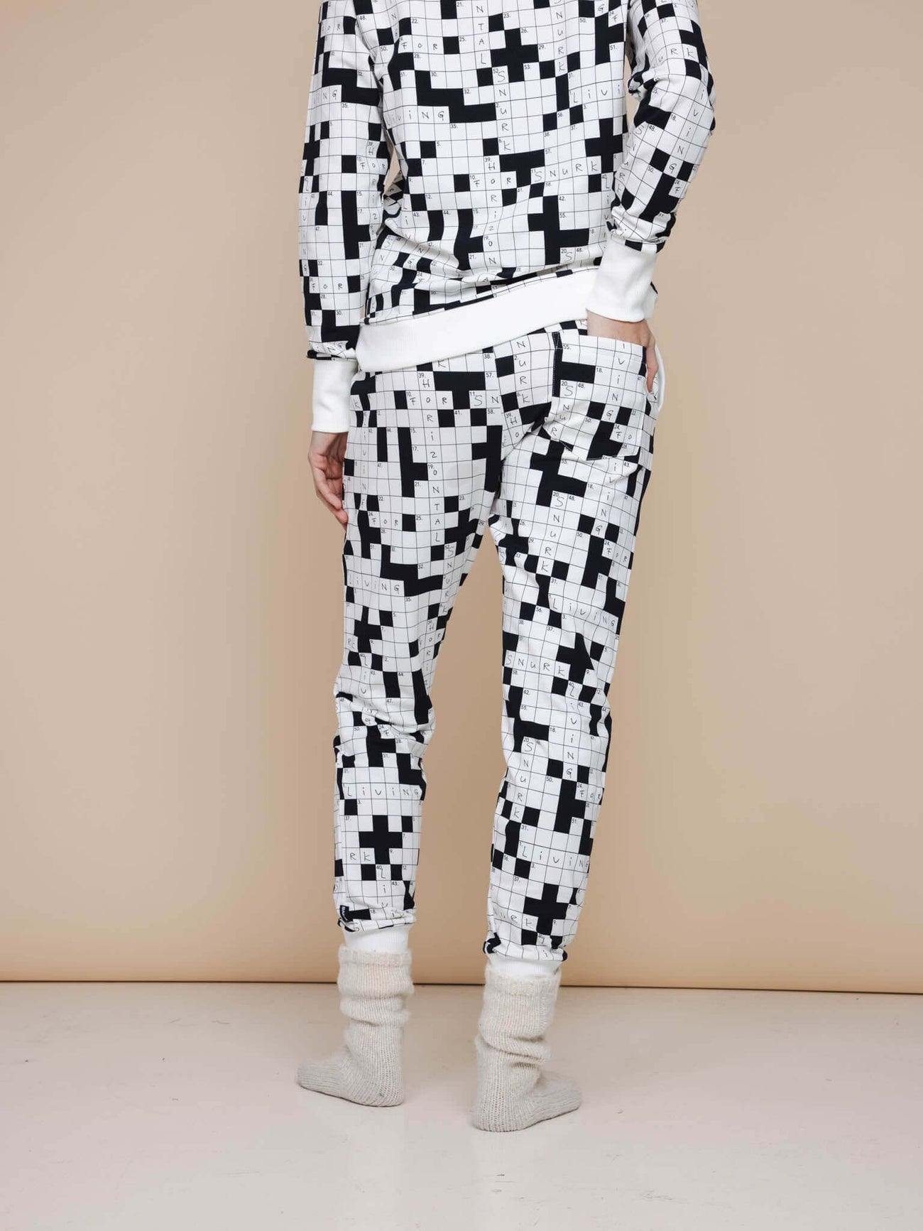 De achterzijde van de SNURK Crossword Broek Regular Unisex met zwart-witte kruiswoordprint voor heren en dames.