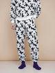 SNURK Crossword Broek Relaxed Unisex in zwart-wit kruiswoordprint met paarse sokken.