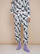 Model draagt SNURK Crossword Broek Relaxed Unisex, zwart-witte kruiswoordprint joggingbroek met zachte biologische katoen.