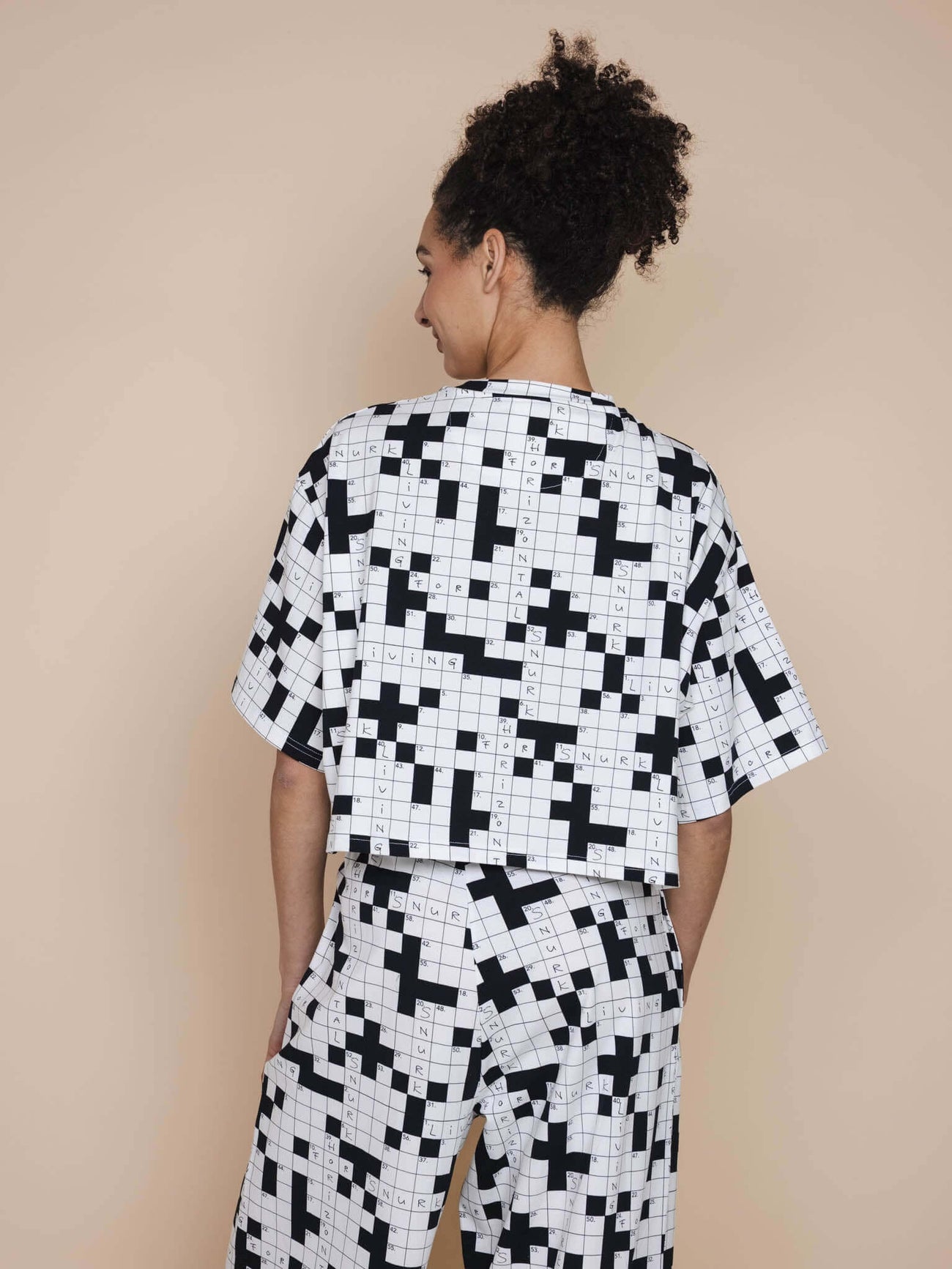 SNURK Crossword Cropped T-shirt Dames van achteren gezien, met een zwart-wit kruiswoordpatroon.