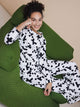 Model draagt SNURK Crossword Long Sleeve T-shirt Dames op een groene bank, glimlachend en ontspannen.
