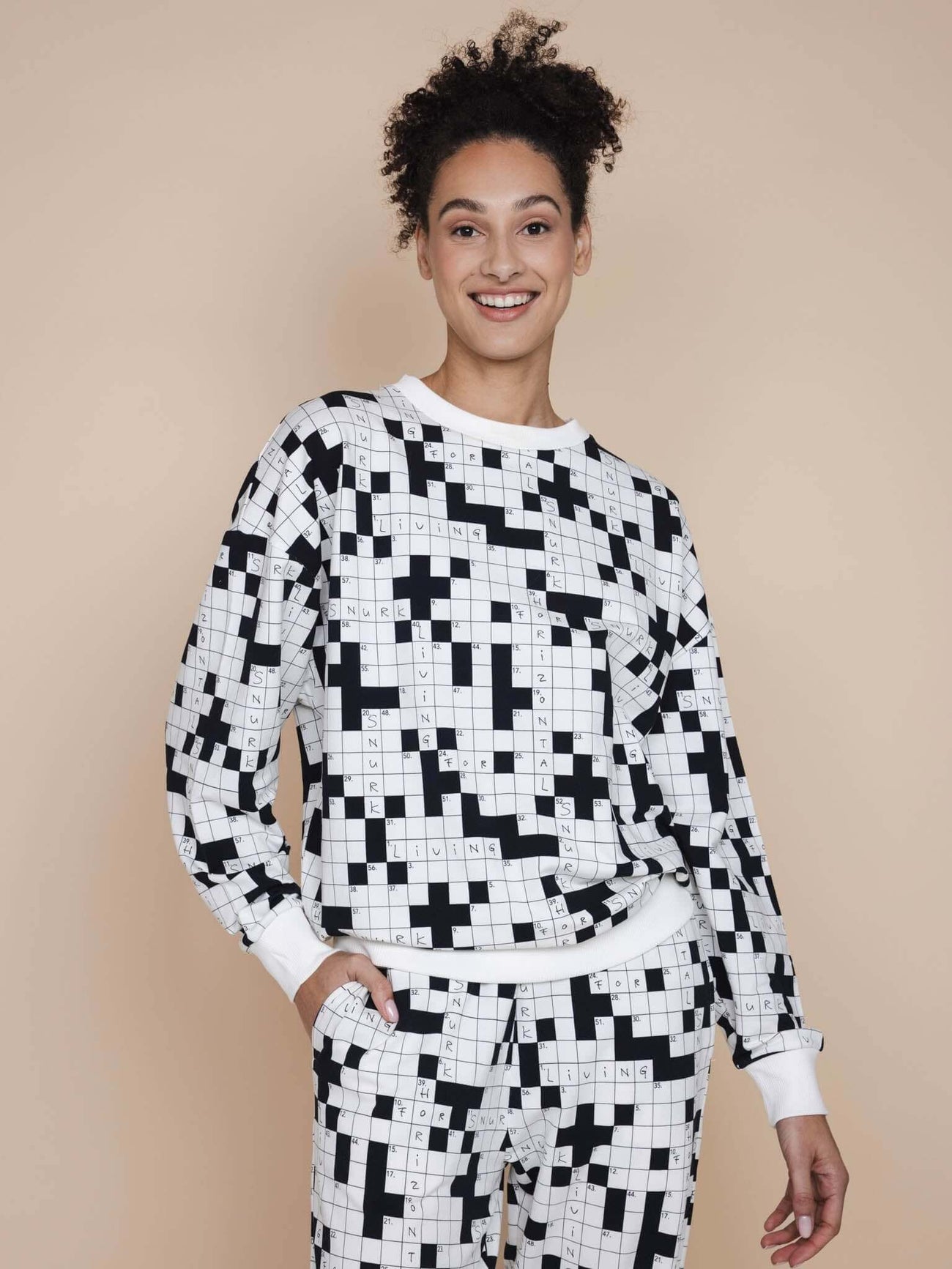 SNURK Crossword Sweater Unisex in zwart-wit, relaxte pasvorm met kruiswoordprint, gemaakt van zachte biologische stretchkatoen.