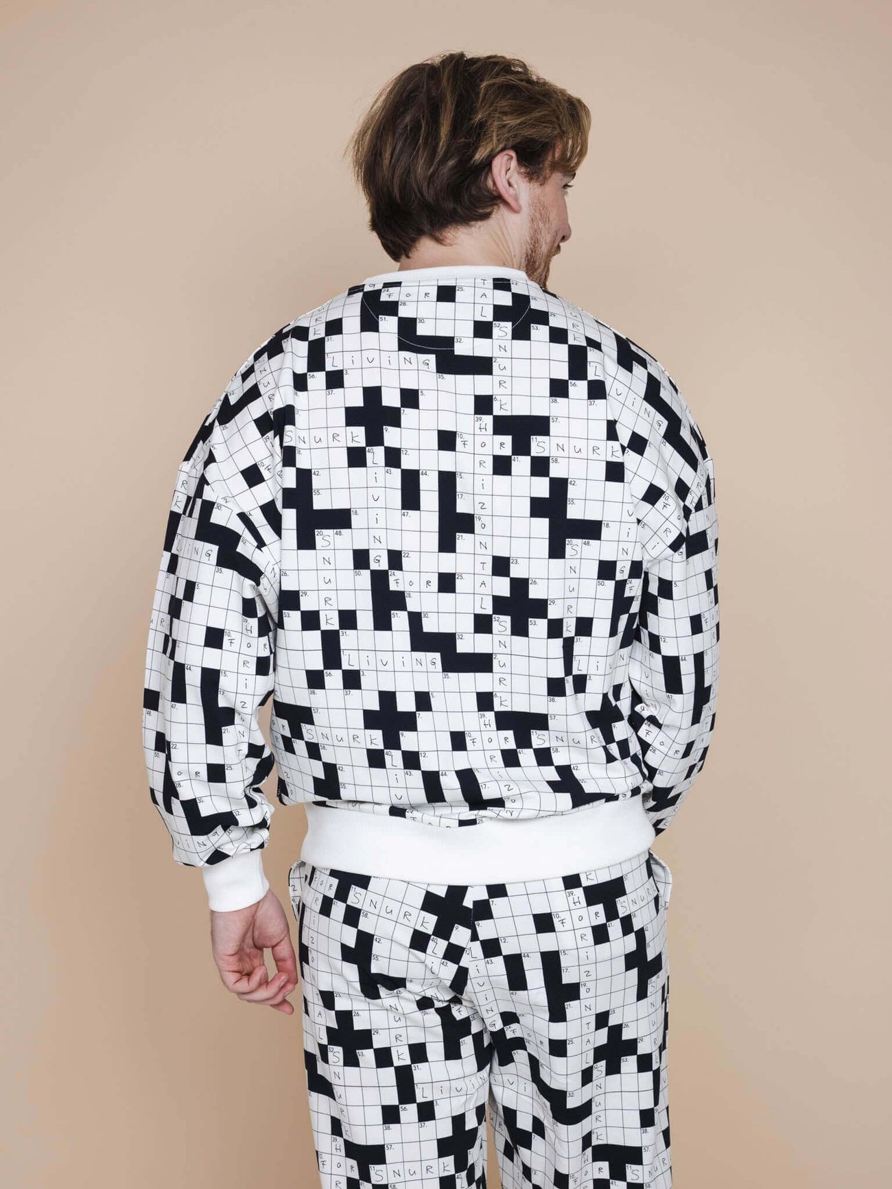 SNURK Crossword Sweater Unisex, zwart-wit kruiswoordprint, ontspannen pasvorm, comfortabele biologische stretchkatoen.