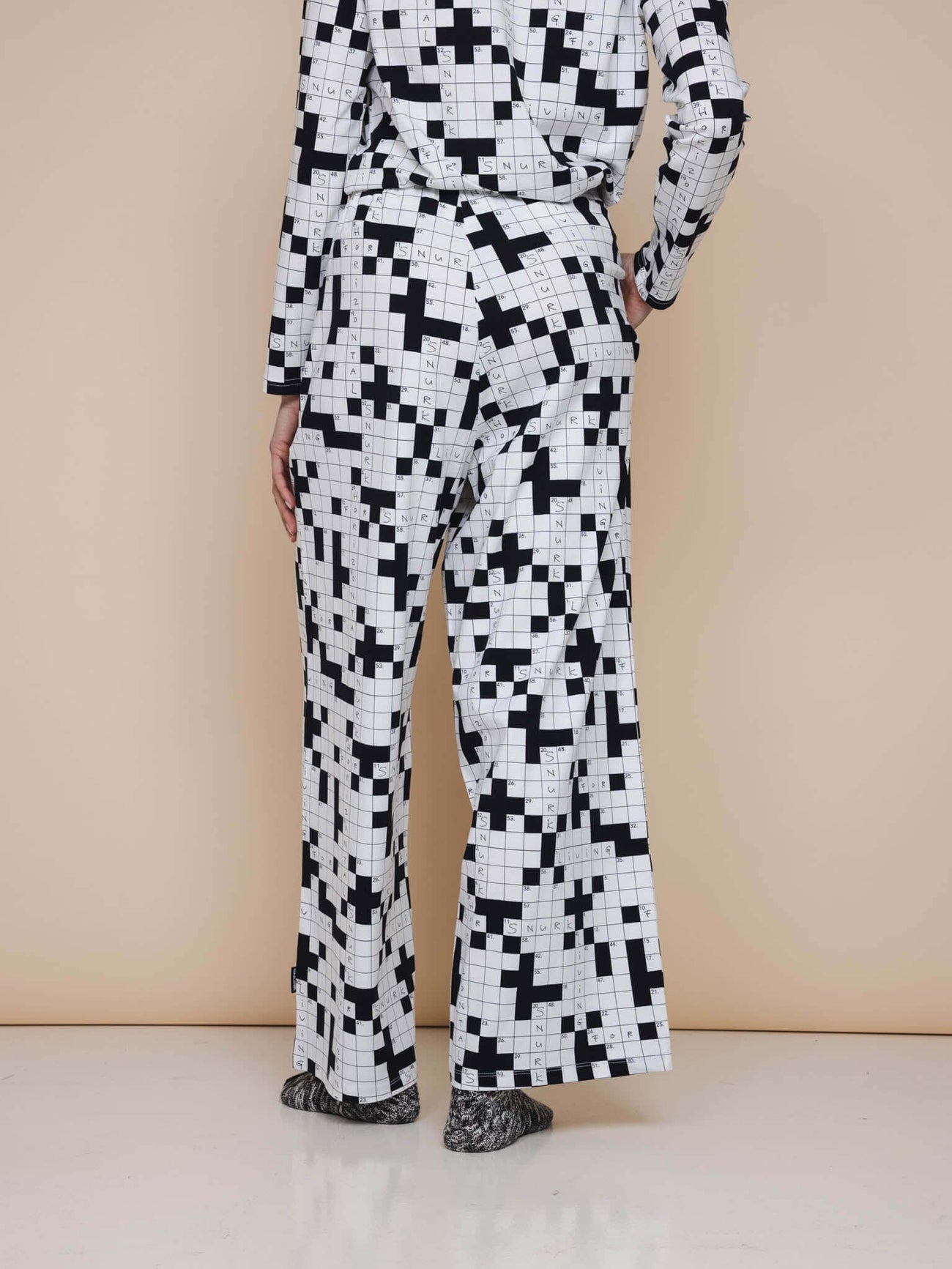 SNURK Crossword Wijde broek Dames achterkant met wijde pijpen en kruiswoordprint in zwart-wit.