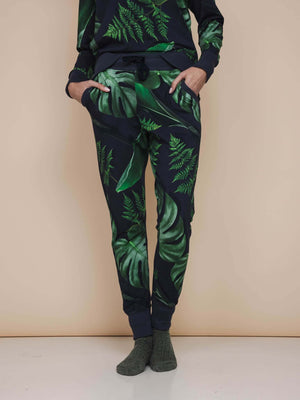 SNURK Dark Forest Broek Regular Unisex met grote donkergroene bladeren op antracietgrijze achtergrond.