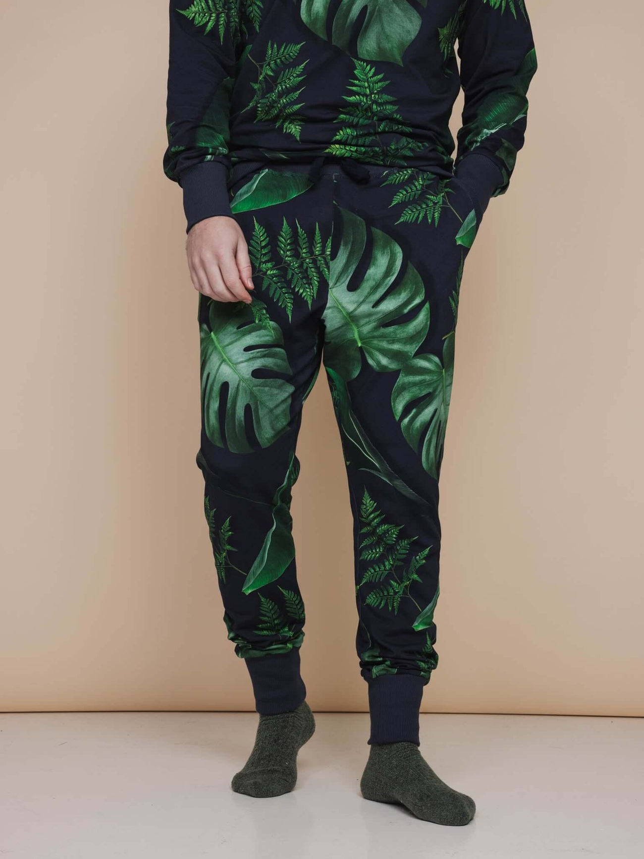 SNURK Dark Forest Broek Regular Unisex in donkergroene bladeren op antracietgrijze achtergrond.