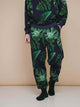 SNURK Dark Forest Broek Relaxed Unisex met een stijlvolle all-over print van grote bladeren.