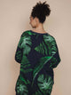SNURK Dark Forest Sweater Dress Dames met grote donkergroene bladeren op een antracietgrijze achtergrond.