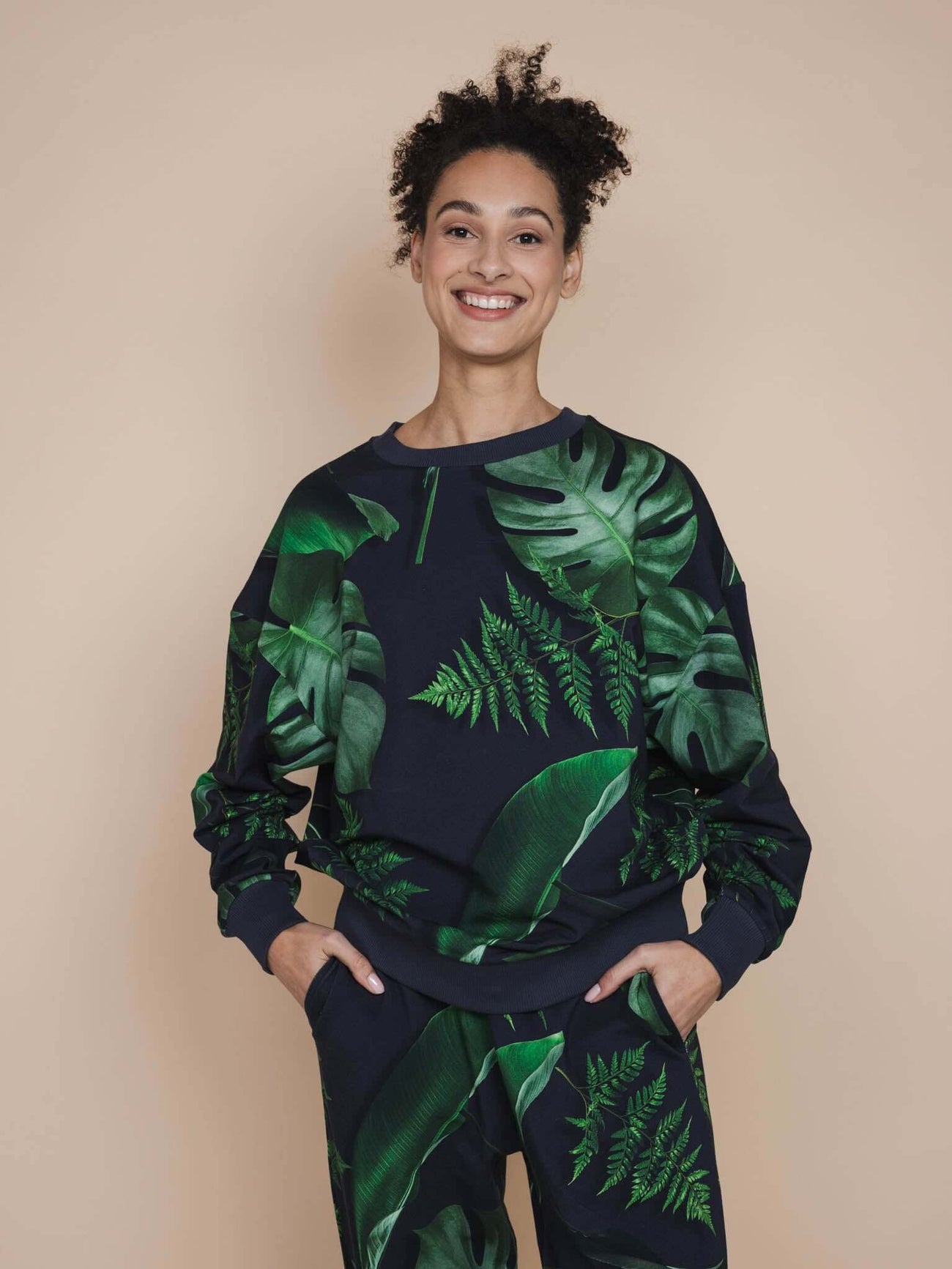 SNURK Dark Forest Sweater Unisex model met donkergroene bladeren op antracietgrijze achtergrond.
