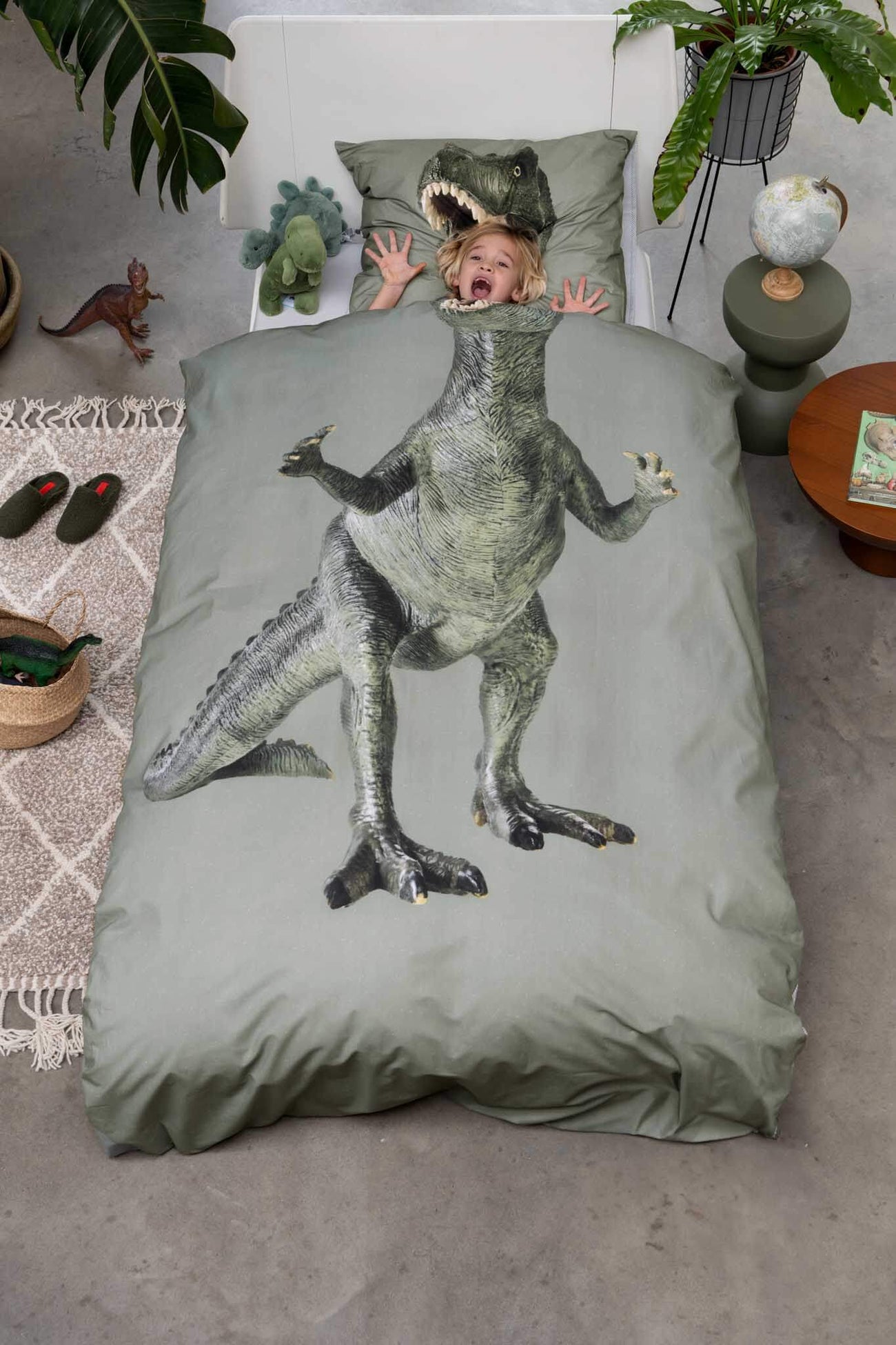 SNURK Dino Green dekbedovertrek met T-Rex print en kind op bed met schrikreactie
