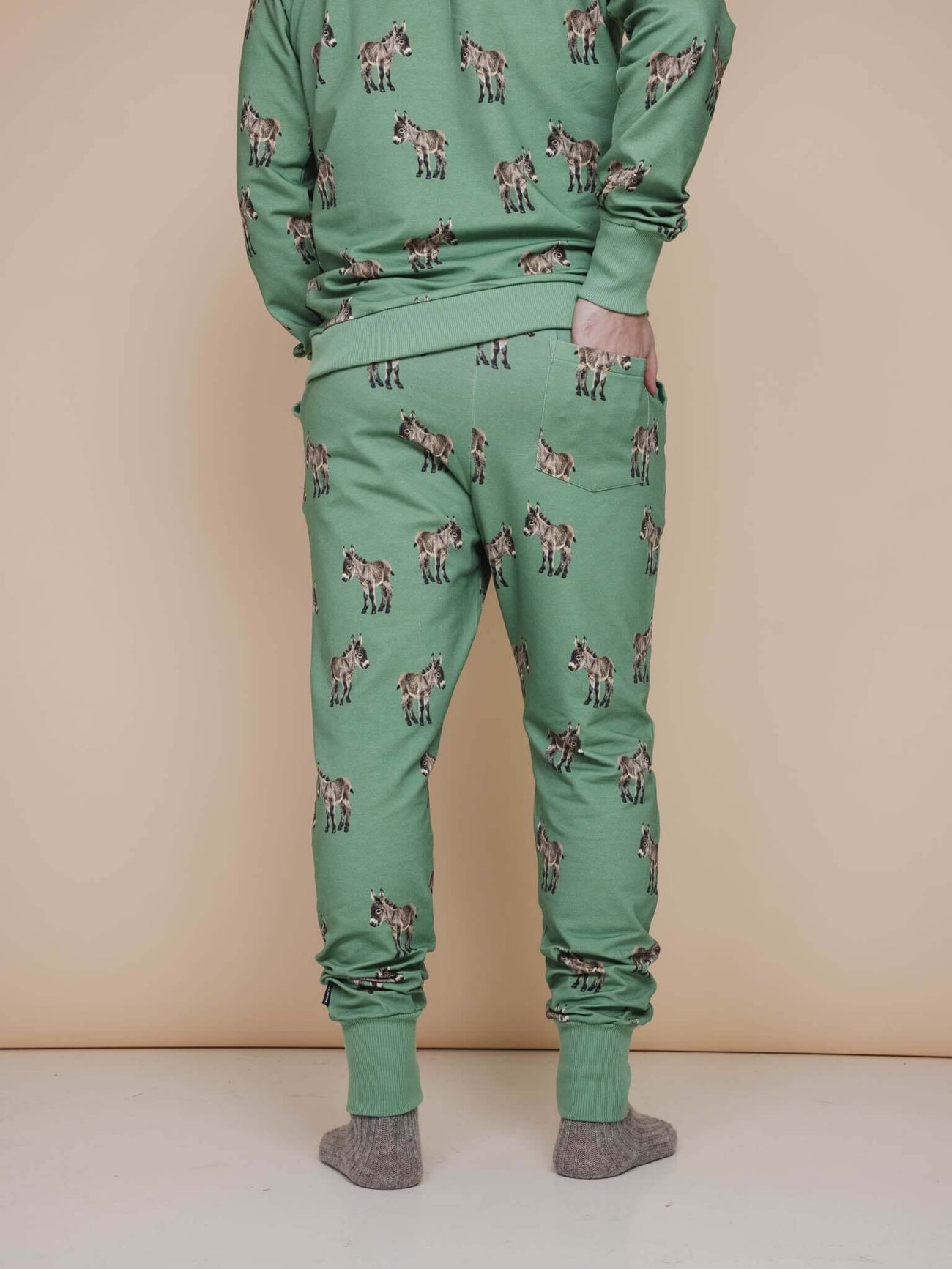 SNURK Donkeys Broek Regular Unisex, groene joggingbroek met schattige baby-ezels op een neutrale achtergrond.