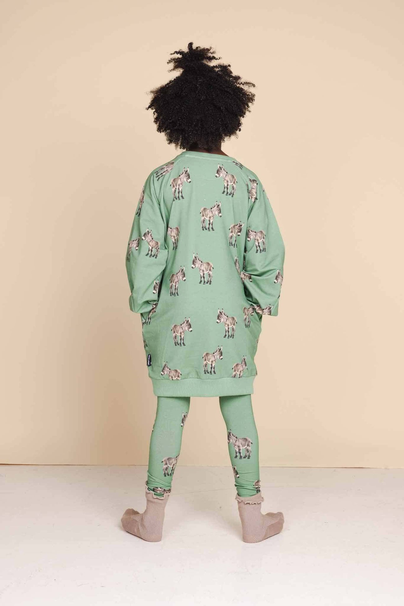SNURK Donkeys Legging Kids met schattige baby-ezels op een zachte groene achtergrond.