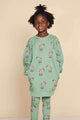 Kind in SNURK Donkeys Legging Kids met schattige baby-ezels op een zachtgroene achtergrond.