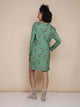 SNURK Donkeys Long Sleeve Dress Dames, een model die het jurkje van achteren laat zien met schattige ezels op een groene achtergrond.