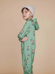 Jongen in SNURK Donkeys Onesie Kids met schattige baby-ezels op een zachtgroene achtergrond.