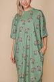 SNURK Donkeys Relaxed Tee Dress Dames, oversized jurk met schattige baby-ezels op een zachtgroene achtergrond.