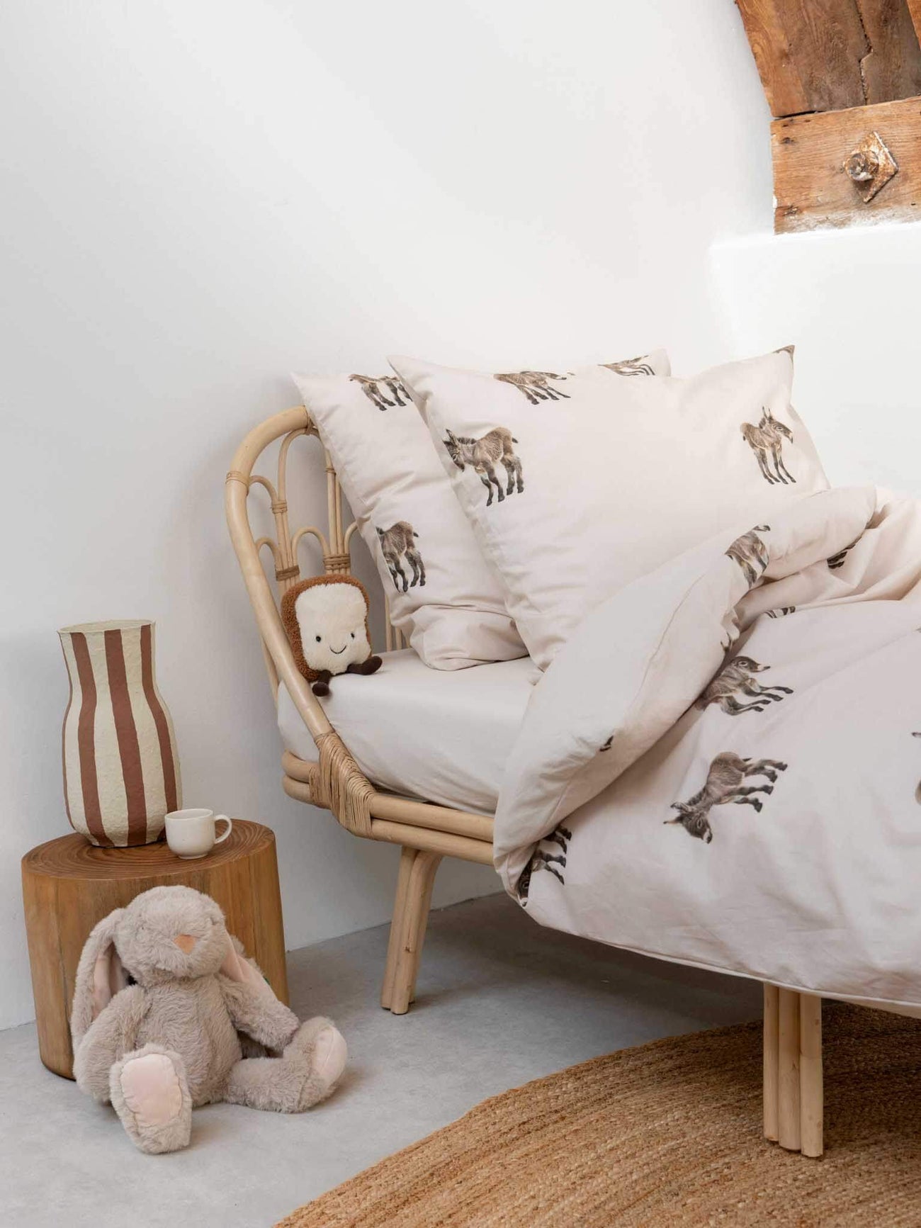 Gezellige slaapkamer met SNURK Donkeys dekbedovertrek, schattige ezels en knuffels op een rieten bed.