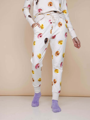 SNURK Donuts Broek Regular Unisex met kleurrijke donuts op een zachte achtergrond, geschikt voor dames en heren.