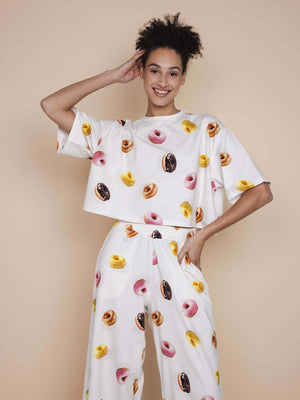 SNURK Donuts Cropped T-shirt Dames met kleurrijke donutprint op een model met een neutrale achtergrond.