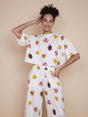 SNURK Donuts Cropped T-shirt Dames met kleurrijke donutprint op een model met een neutrale achtergrond.