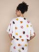 SNURK Donuts Cropped T-shirt Dames met kleurrijke donuts print op een romige achtergrond.