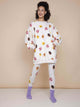 SNURK Donuts Sweater Dress Dames met donutprint op beige achtergrond, gedragen met bijpassende leggings.