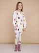 Een meisje in een SNURK Donuts Sweater Dress Kids met leggings, perfect voor chillen en slapen.