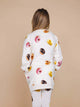 Achteraanzicht van een kind in de SNURK Donuts Sweater Dress Kids met donutfoto's op de jurk, perfect voor chillen.