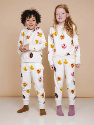 SNURK Donuts Sweater Kids met kleurrijke donutsprint, kinderen in relaxte outfit, zachte biologisch katoen.