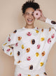 SNURK Donuts Sweater Unisex met kleurrijke donutprint, gedragen door een lachende vrouw.