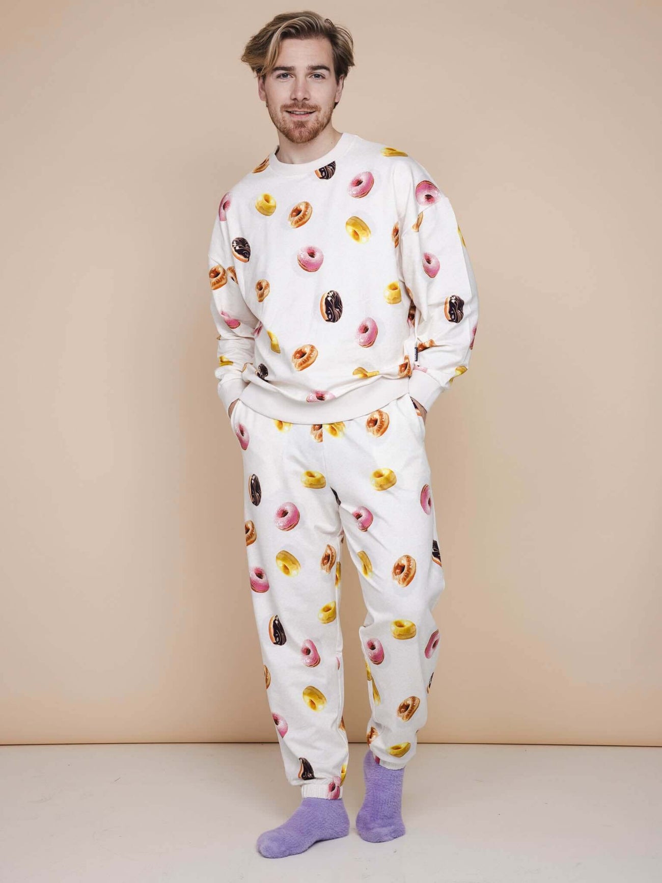 SNURK Donuts Sweater Unisex met kleurrijke donuts op een zachte achtergrond, perfect voor een vrolijke outfit.