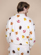 SNURK Donuts Sweater Unisex met kleurrijke donutprints op een zachte beige achtergrond.