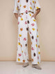 Model draagt SNURK Donuts Wijde broek Dames met kleurrijke donutprint en diepe steekzakken.