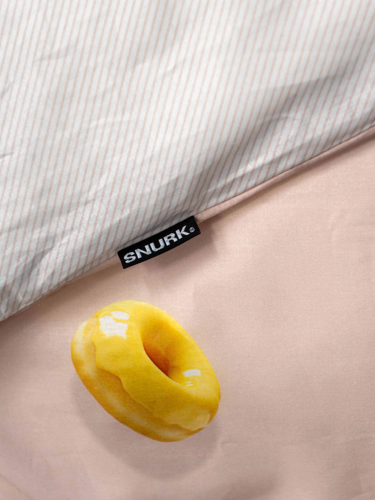 SNURK Donuts dekbedovertrek met een schattige donut op een lichtroze ondergrond en gestreepte bovenkant.