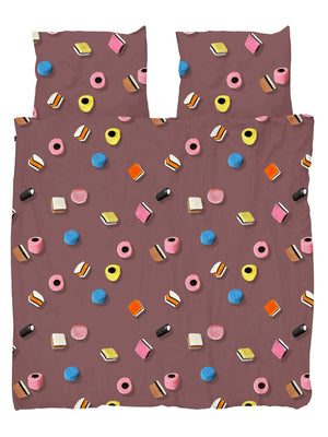 SNURK Drop It dekbedovertrek met kleurrijke Engelse snoepjes op een bruin-roze achtergrond.