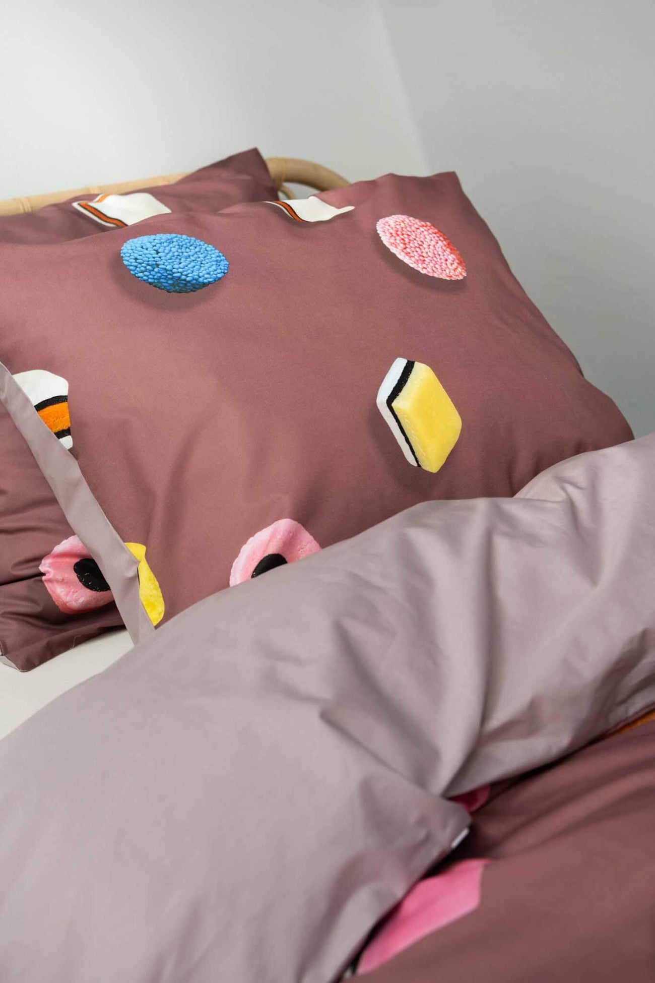 SNURK Drop It dekbedovertrek met kleurrijke dropjes op een zachte achtergrond voor een vrolijke slaapkamer.