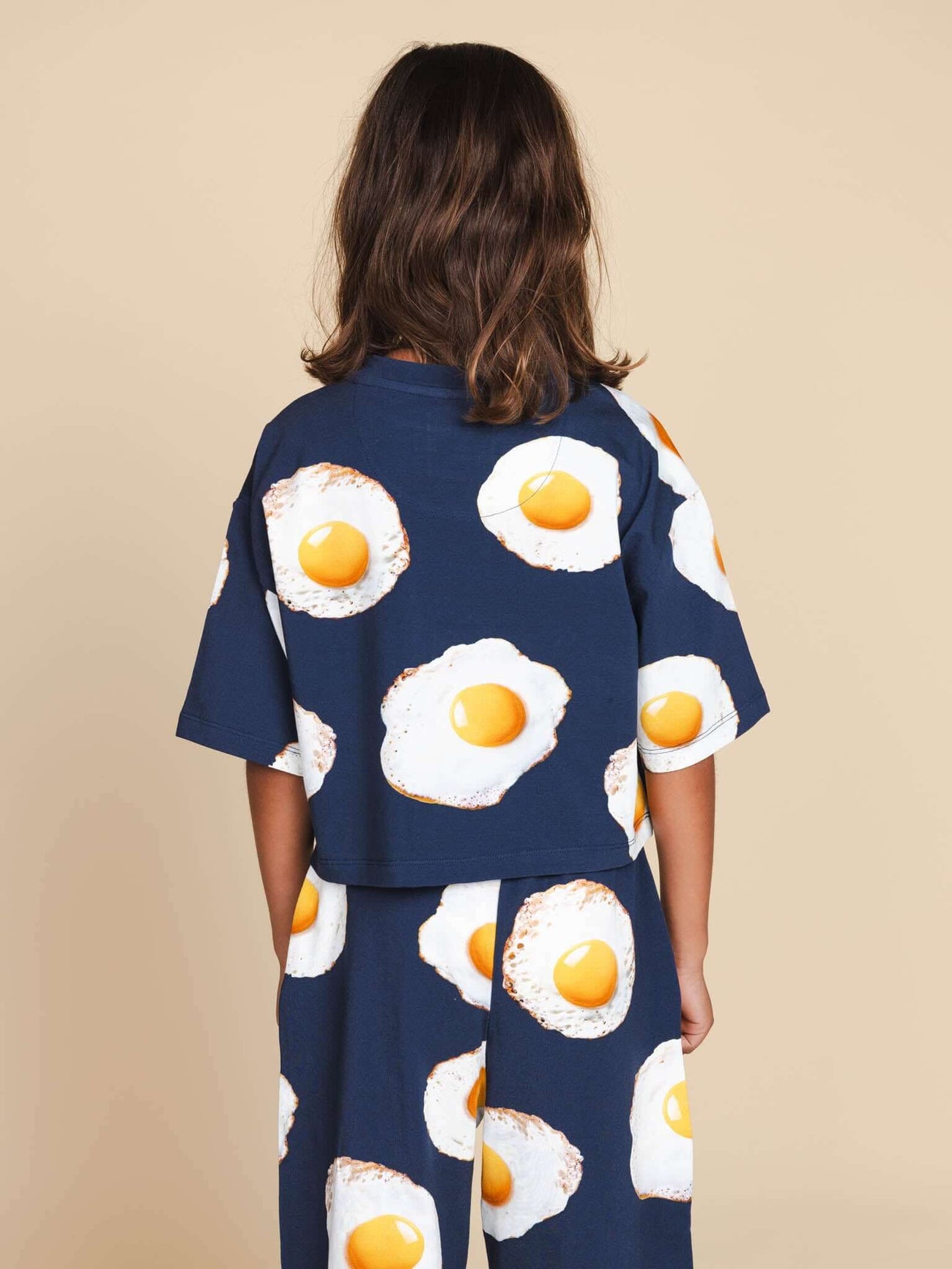 SNURK Eggs Navy Cropped T-Shirt Kids met gebakken eitjes, achteraanzicht van een meisje in de t-shirt.