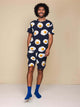Man in SNURK Eggs Navy Shorts Heren met spiegeleitjesprint, lachend tegen een neutrale achtergrond.