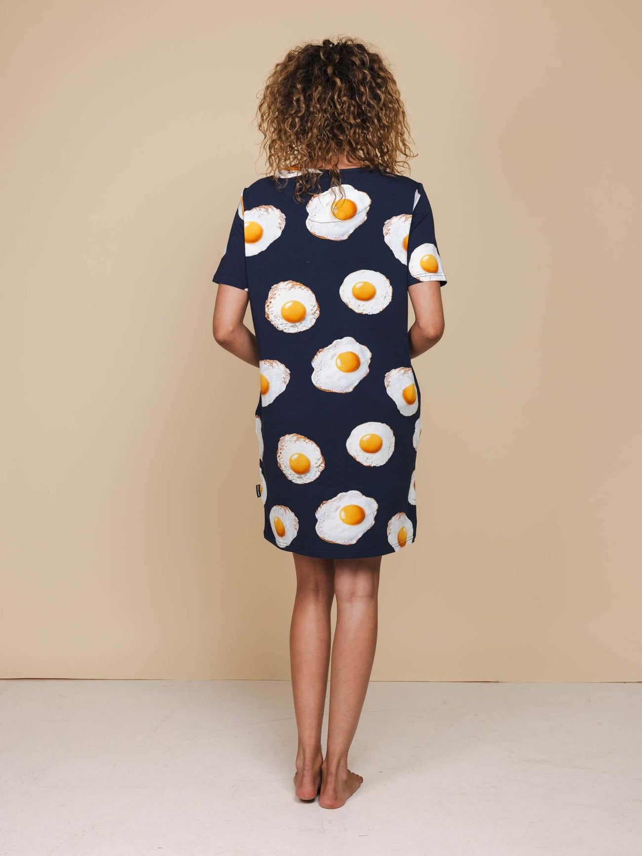 SNURK Eggs Navy T-shirt Dress Dames van achteren met spiegeleitjesprint op een navy achtergrond.