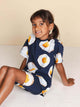 SNURK Eggs Navy T-shirt Kids gedragen door een vrolijk kind, met een design van spiegeleitjes op een navy achtergrond.