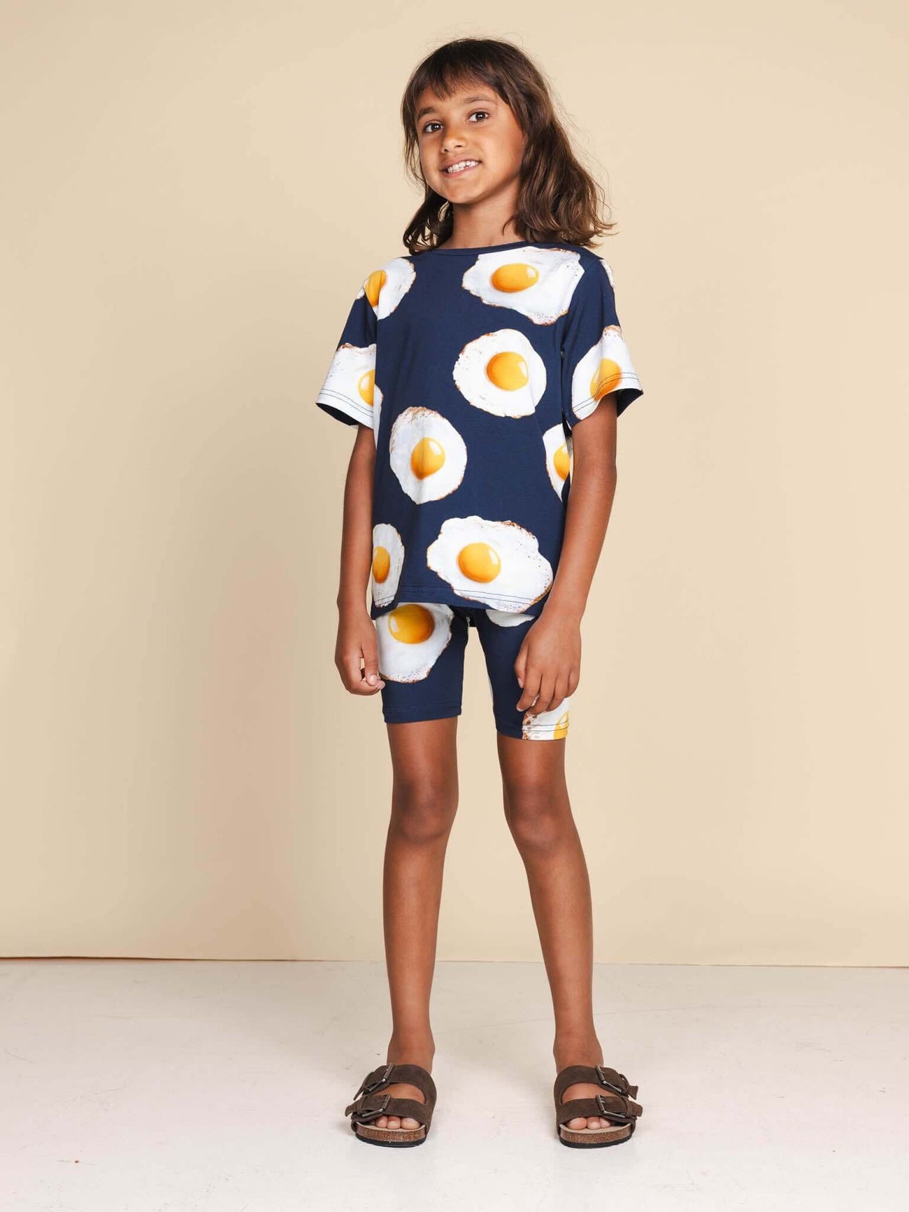 SNURK Eggs Navy T-shirt Kids met spiegeleitjesprint gedragen door een glimlachend kind.