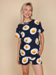 SNURK Eggs Navy T-shirt Unisex met spiegeleitjes op een model tegen een beige achtergrond.