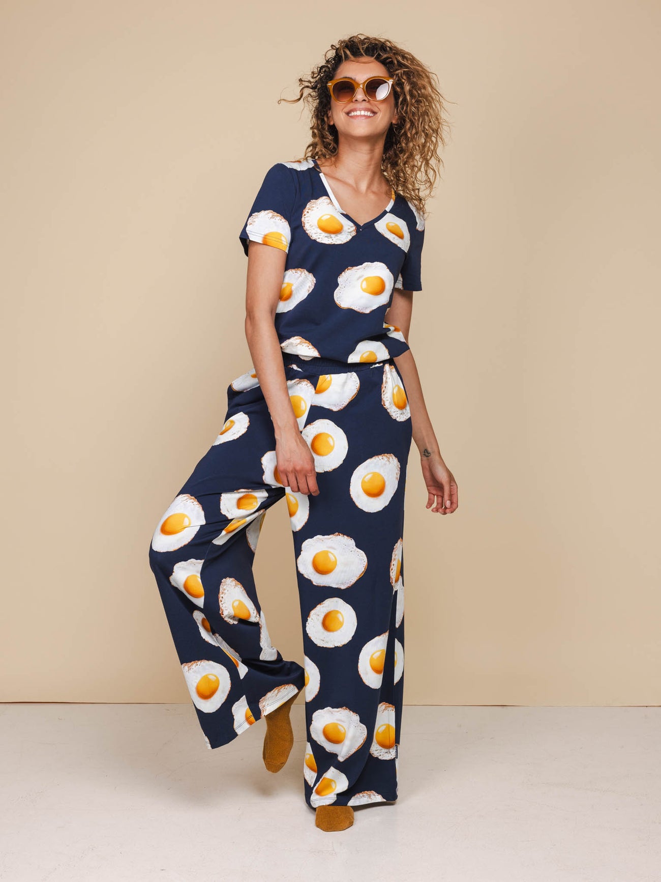 Vrouw in SNURK Eggs Navy V-Neck T-shirt Dames met spiegeleitjesprint in relaxte outfit.
