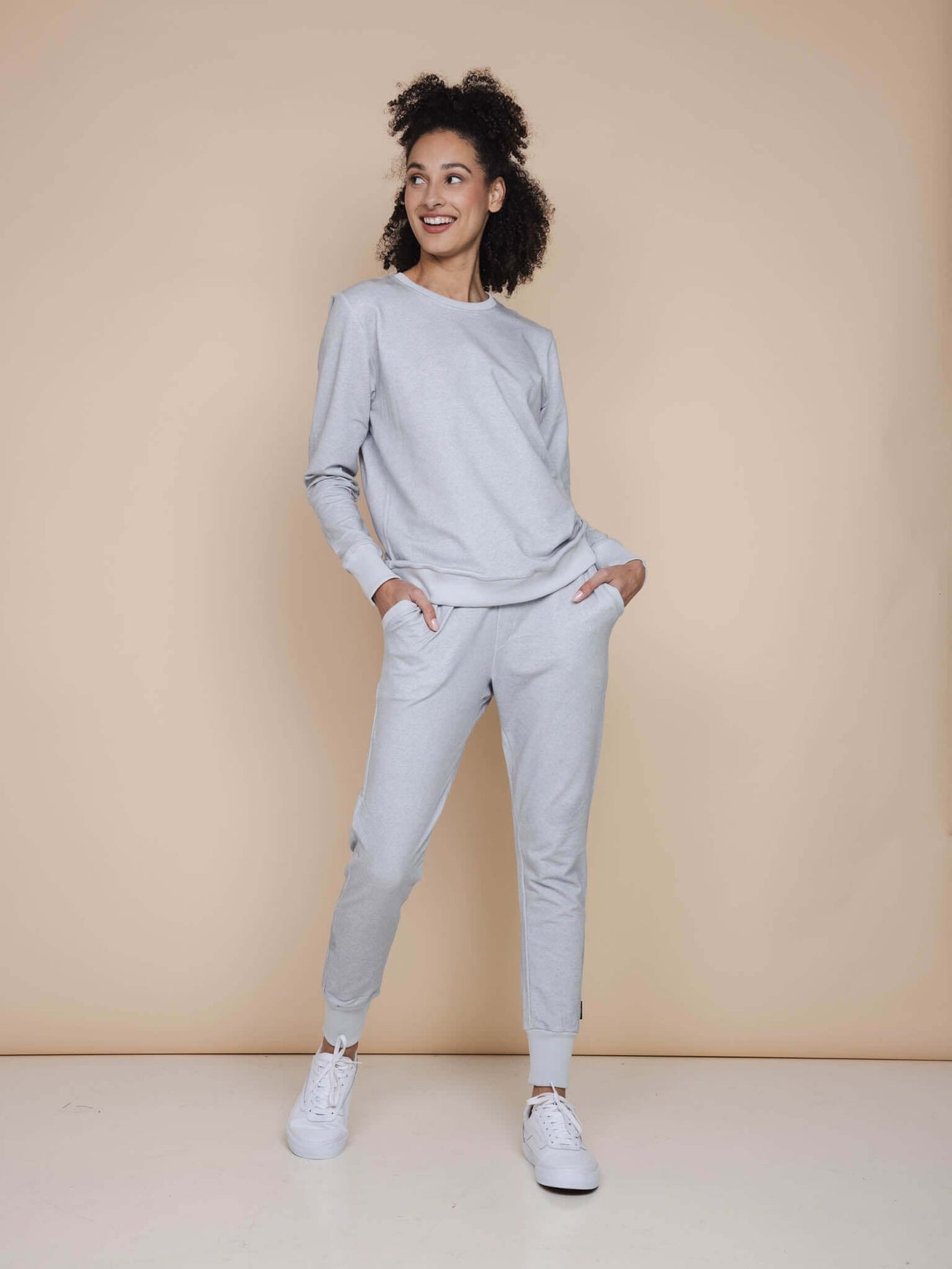 SNURK Grey Broek Regular Unisex model in lichtgrijze joggingbroek met top, vrolijk lachend.