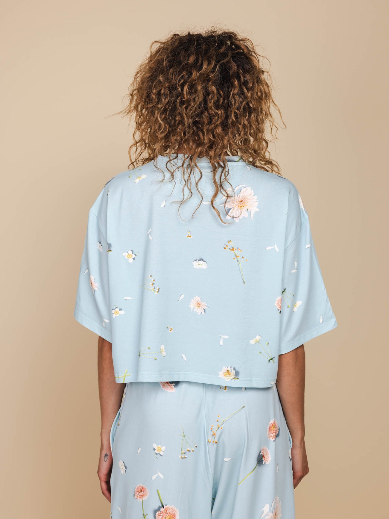 SNURK Hopeless Romantic Cropped T-Shirt Dames achterkant met bloemetjesprint op een lichte achtergrond.