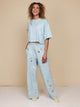 SNURK Hopeless Romantic Cropped T-Shirt Dames in een vrolijke bloemetjesprint, gecombineerd met matching broek.
