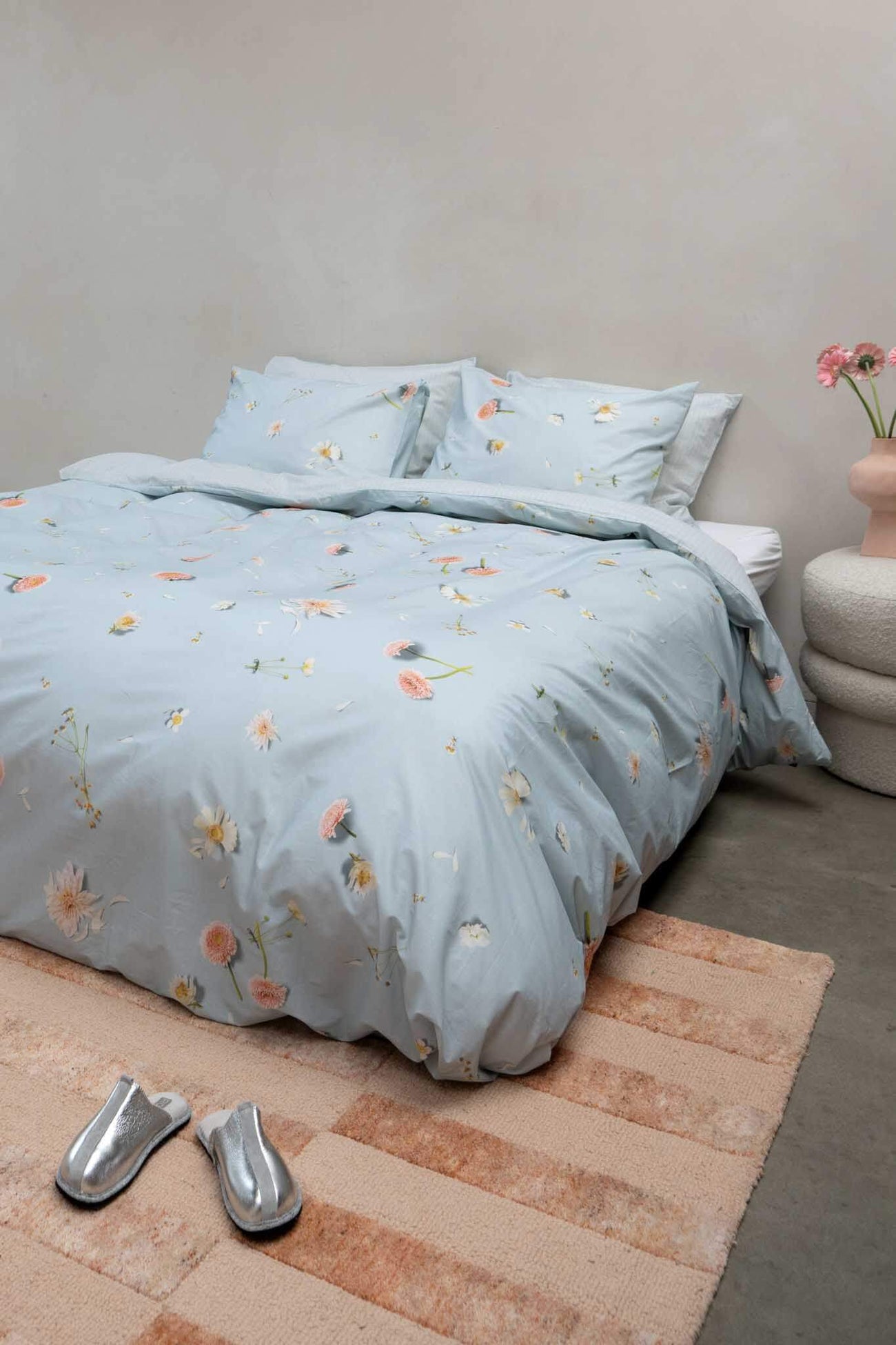 SNURK Hopeless Romantic dekbedovertrek met bloemenprint op een lichtblauwe ondergrond in een slaapkamer.