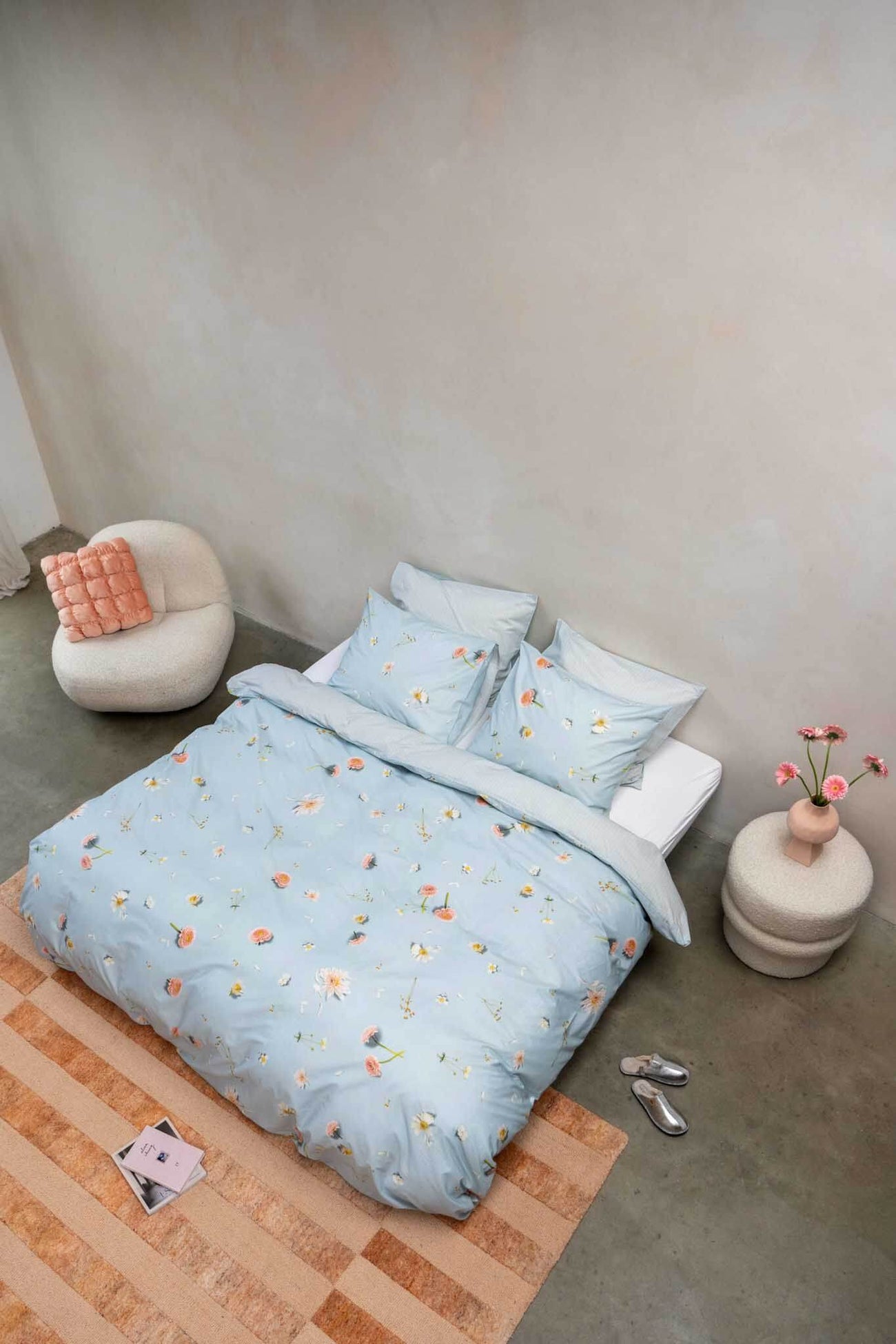 SNURK Hopeless Romantic dekbedovertrek op bed met bloemenprint en zachte kussens.