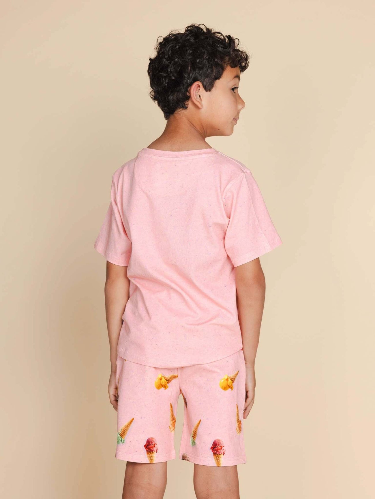 Achteraanzicht van een kind dat het SNURK Ice Cream Cones T-shirt Kids draagt met vrolijke shorts.